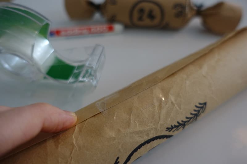 Das Packpapier mit einem Tesa Klebstreifen zu kleben